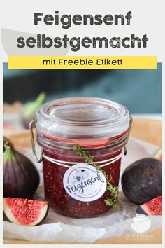 a jar filled with fruit sitting on top of a wooden table next to sliced figs