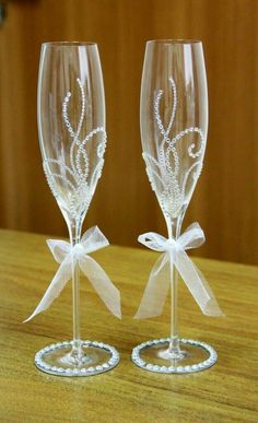 two wine glasses with bows are sitting on a table