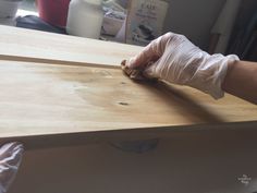 a person in white gloves is working on a piece of plywood counter top with wood planks