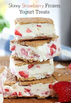 strawberry shortbread ice cream sandwiches stacked on top of each other with strawberries in the background