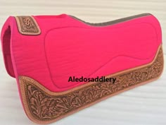 a pink and brown purse sitting on top of a white table