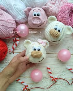 three crocheted stuffed animals sitting on top of a table next to balls of yarn