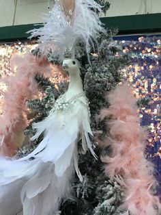 a white and pink christmas tree decorated with feathers