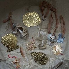 there are many different items on the table with ribbons and decorations around them, including seashells