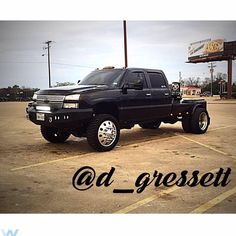 a black truck parked in a parking lot with the words ad gresset above it