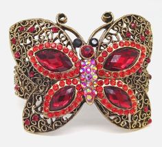 This stunning sparkly butterfly statement bracelet is a must-have for any fashion-forward individual. The bracelet features beautiful red rhinestones and red aurora borealis crystals that sparkle in the light. The gold tone metal cuff is hinged and has a secure closure, ensuring that the bracelet stays in place. Measuring 2.95 inches in length, this bracelet is the perfect size to fit most wrists comfortably. The bracelet measures approximately 2.43" high x 2.95" wide x 2.26" deep. Please note t Sparkly Butterfly, Red Aurora Borealis, Aurora Borealis Crystal, Butterfly Shape, Red Rhinestone, Statement Bracelet, Aurora Borealis, High Heel Boots, Gold Tone Metal