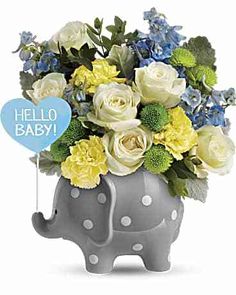 a baby elephant bouquet with blue and yellow flowers in it's trunk that says hello baby