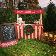 a sign that is on the grass next to a table with a chalkboard and wreath