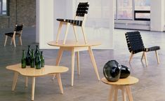 several chairs and tables with vases on them in an empty room next to each other