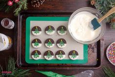 decorated cookies on a tray with icing and sprinkles next to it