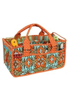 an orange and blue patterned bag with sewing supplies in the bottom section, on a white background