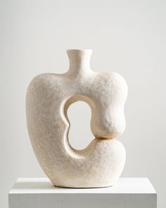 a white vase sitting on top of a table