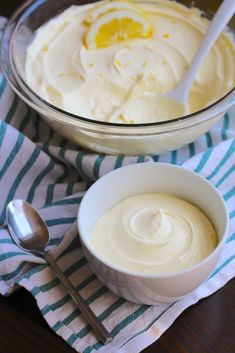 two bowls filled with food on top of a blue and white striped napkin next to spoons