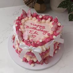 a heart shaped birthday cake with pink frosting