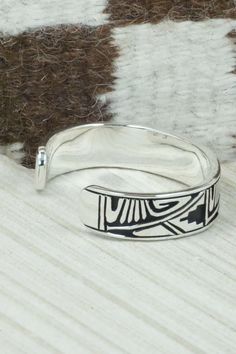 This sterling silver and bracelet was made by Navajo silversmith Kerry Begay. The inside is signed KB and stamped sterling.Size: 5" (will fit up to a 6" wrist)Gap: 1"Width: 1/2"Free shipping on all orders! We ship with USPS and always include tracking. All orders ship within a day of payment.Returns are accepted up to 30 days after you receive your order. Just send us a message. Our shop offers cash back or store credit. The item must be returned in new condition. Southwestern Engraved Sterling Silver Bracelet Gift, Engraved Sterling Silver Bracelet Gift, Southwestern Sterling Silver Bracelet Stamped 925 As Gift, Traditional Sterling Silver Nickel-free Bracelet, Traditional Nickel-free Sterling Silver Bracelet, Stamped Sterling Silver Bangle, Stamped Sterling Silver Bangle Bracelet, Sterling Silver Etched Cuff Bracelet, Etched Sterling Silver Bracelet In Traditional Style