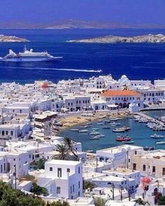 an aerial view of a city with boats in the water and a cruise ship out in the distance