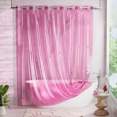 a pink shower curtain in a bathroom next to a bathtub and potted plant