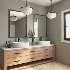 a bathroom with two sinks and mirrors on the wall, along with a vase filled with flowers