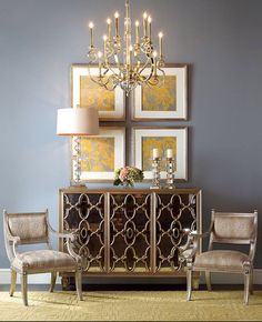 an elegant dining room with chandelier, chairs and pictures on the wall above it