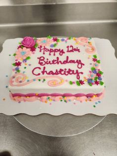 a birthday cake with white frosting and pink icing