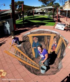 a woman is painting a mural on the ground