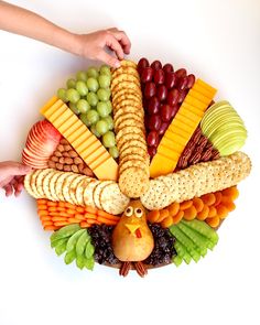 a turkey shaped platter filled with cheese, crackers, grapes, and nuts