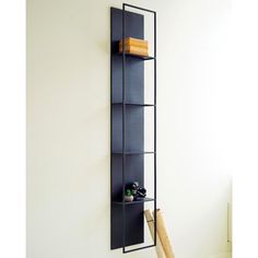 a baseball bat and some books on a shelf in a room with white wall paint