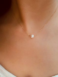 "➤ Spend $80 or above and get a FREE travel size jewellery box packed with your order. *Total transaction excludes shipping. One box per single transaction only. While stock lasts. Promo ends Dec 2023. This Large Solo Pearl Necklace is a unique piece that perfectly embodies elegance and simplicity. Handcrafted with love and precision, this necklace is more than just an accessory - it's a statement. Whether you're attending a wedding or simply dressing up for a day at work, this piece will add a Simple Everyday Jewelry With Pearl Charm, Pearl Clavicle Chain Jewelry For Gift, Delicate Necklace With Simple Design For Gifts, Delicate Simple Necklace For Gift, Dainty White Gold Pearl Necklace For Anniversary, Delicate Simple Design Necklace For Gift, Classic Pearl Necklace For Gift, Minimalist Single Strand Pearl Necklace For Anniversary, Fine Jewelry Wedding Charm Necklace With Clavicle Chain