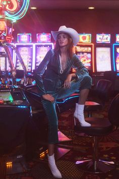 a woman sitting on top of a chair in front of slot machines