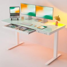 a computer desk with two monitors and a laptop on it, sitting next to each other