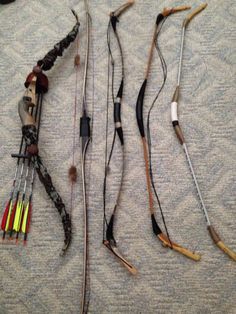 an assortment of different types of arrows laid out on a bed with one arrow in the middle