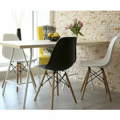 a dining table with four chairs and a vase filled with flowers on top of it