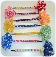 several different colored hair clips with polka dots and bows on them, all lined up in a row