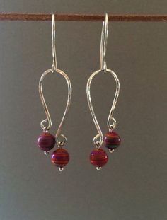 the earrings have been made with silver wire and red glass beaded beads on them