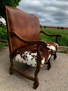 a cow hide chair sitting on top of a gravel road