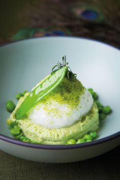 a white bowl filled with green food on top of a table