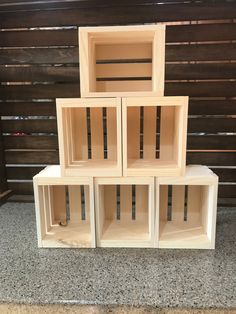 four wooden shelves stacked on top of each other in front of a wall with wood slats