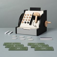 an old fashioned pay phone sitting on top of a table next to some green and white numbers