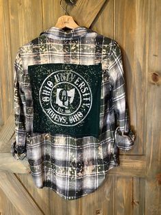 Artfully distressed, upcycled and sustainable flannel shirt paired with upcycled tee with graphic.  Unisex in style but sourced from a variety of brands so resized for a roomy women's fit.  All one of kind and unless noted, flannel is medium weight.  Show your pride with a unique spirit wear  that only you will have. Embellished Flannel Shirts, Casual Flannel Patchwork Top, Casual Flannel Top With Patchwork, Casual Distressed Shirt For Fall, Casual Fall Tops With Patches, Vintage Flannel Top With Graphic Print, Fall Cotton Flannel Shirt With Graphic Print, Fall Flannel Top With Graphic Print, Plaid Cotton Flannel Shirt With Graphic Print