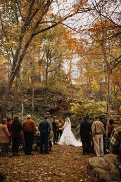 the bride and groom are getting married in the woods