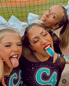 three cheerleaders with their mouths open and tongue out