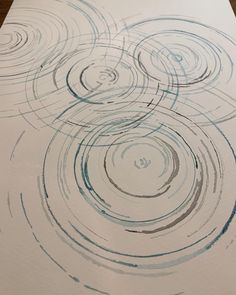 an artistic drawing on paper with blue and gray swirls