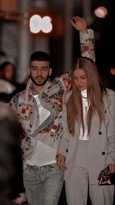 the man and woman are walking down the runway