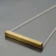 This simple brass necklace is made from silver plated chain and square brass tubing that I found at a salvage yard. The brass bar has been cut to 3" long, and a little over a 1/4" wide. I sanded the pendant to give it a brushed finish. You can select the length of the necklace from the drop box at the right side of the top of this page. The necklace has a gold plated hook and eye style clasp. This necklace is made to order, so it will vary slightly from the one pictured. The necklace is also ava Minimalist Brass Necklace With Rectangular Pendant, Guitar Jewelry, Guitar String Jewelry, Guitar String Bracelet, Brass Chain Necklace, Found Object Jewelry, Paper Beads Necklace, Brass Tube, Hardware Jewelry