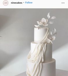 a white wedding cake with flowers on top