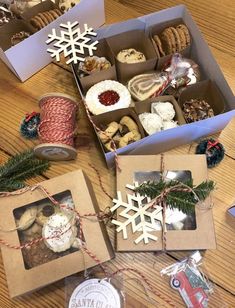 boxes filled with different types of pastries on top of a wooden table next to twine spools