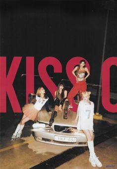 four girls posing in front of a car with the word kisso on it's side