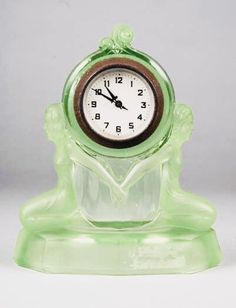 a green glass clock sitting on top of a table