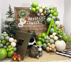 an assortment of green and white decorations on display in front of a happy camper sign