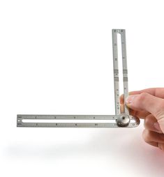 a person is holding a metal ruler in their left hand and measuring it with the other hand